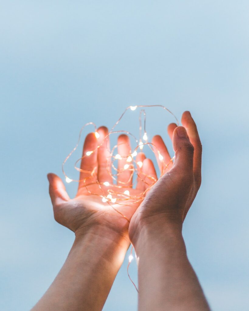Donere person holding string lights